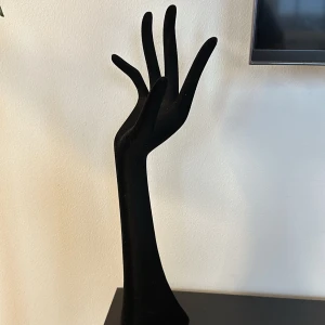 Svart smyckeshand - Elegant svart smyckeshand för att visa upp ringar och armband. Perfekt för att organisera och visa dina smycken på ett stilfullt sätt. Tillverkad i ett mjukt material som ger en lyxig känsla.