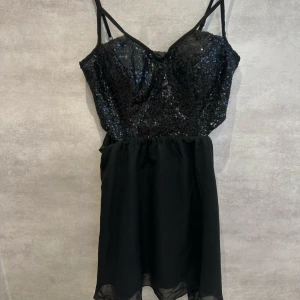 Svart paljettklänning från Estradeur - Snygg svart fest klänning från Estradeur med glittriga paljetter upptill och smala reglerbara axelband. Köpt på Nelly och använd bara någon enstaka gång. Superfin verkligen🖤