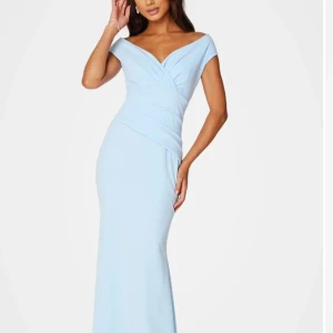 Ljusblå långklänning - Elegant ljusblå långklänning med offshoulder-design och omlott-detaljer. En så så fin klänning som är i mycket bra skick, endast använd en gång (på ett bröllop). En klänning som är prefekt för dig som söker t.ex en balklänning!! Hör av er vid frågor osv💙💙💙klänningen passar dig med stl xs-s, väldigt skönt och bekvämt material!! Vill även tillägga att klänning är helt slutsåld på hemsidan(bubelroom)🥰🥰