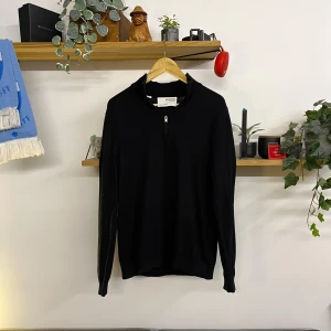 Svart tröja med dragkedja från Selected Homme - Snygg svart tröja från Selected Homme med dragkedja vid halsen. Perfekt för en stilren look. Tröjan har långa ärmar och är tillverkad i ett mjukt material.