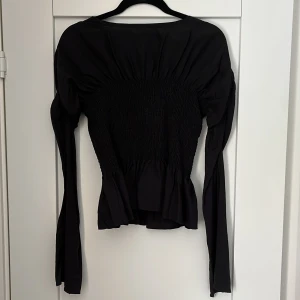 Svart långärmad topp - Snygg svart långärmad topp med smockdetaljer som ger en fin passform. Perfekt för festligare tillfällen ⚡️⚡️