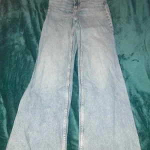 Ljusa jeans från H&M - Säljer ett par ljusa jeans från H&M med hög midja och vida ben. Perfekta för en avslappnad stil. Tillverkade i bomull för en bekväm passform.
