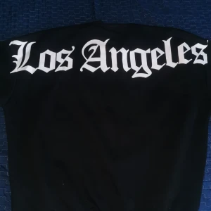 Svart tröja med Los Angeles-tryck från Black Sound - Snygg svart tröja från Black Sound med stort 'Los Angeles'-tryck i vitt på ryggen. Perfekt för en avslappnad stil.