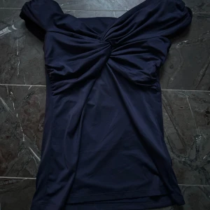 Mörkblå offshoulder topp - Snygg mörkblå offshoulder topp med en knutdetalj framtill. Perfekt kvällstopp!! Toppen är ifrån HM men säljs inte mer tyvärr…