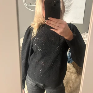 Svart spetsmönstrad tröja - Snygg svart tröja med spetsmönster och långa ärmar. Perfekt för en stilren look med en touch av elegans. Passar bra till både jeans och kjol.