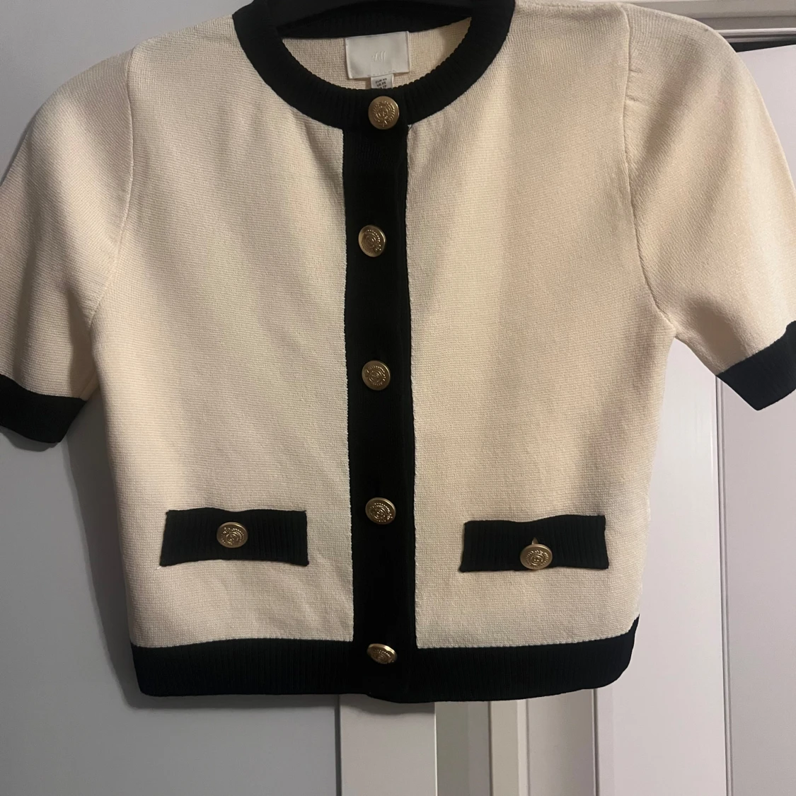 Vit och svart kofta med guldknappar