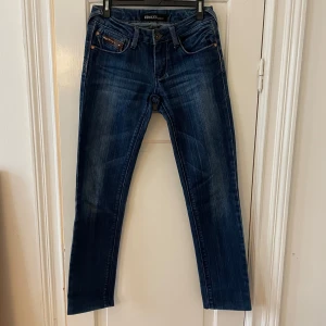 Blå jeans raka jeans med broderade fickor  - Snygga blå jeans med broderade detaljer på bakfickorna.Jeansen är raka i modellen och är i fint skick