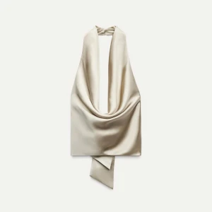 Beige halterneck topp - Beige halterneck topp i satin och knytning i ryggen. Helt ny, aldrig använd. Prislappen sitter kvar