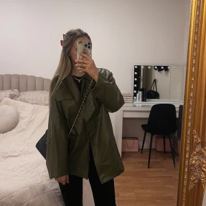 Olivgrön skinnjacka - Snygg olivgrön jacka i skinnimitation med knytband i midjan. 🖤passar xs-m