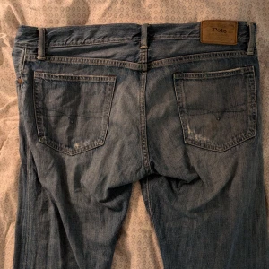 Blå jeans från Polo Ralph Lauren - Säljer ett par klassiska blå jeans från Polo Ralph Lauren. Vecken i tyget är design. De är slim fit och storlek L. 