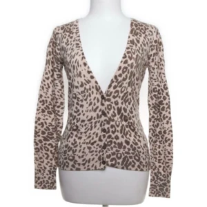 Zara Leopard kofta - Snygg leopardmönstrad kofta med djup v-ringning och långa ärmar. Perfekt för att ge din outfit en trendig touch. Koftan är i en beige och brun färgkombination.