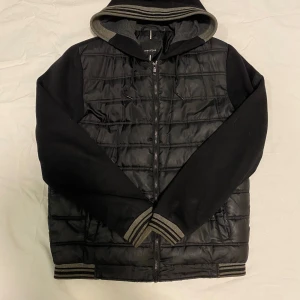 Cardigan jacka - Snygg svart quiltad jacka från greystone med huva och dragkedja. Jackan har långa ärmar och ribbade muddar i grått och svart. Perfekt för kyligare dagar. Väldigt laidback | skick 10/10