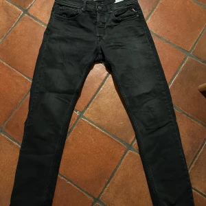 Svarta jeans från Replay - Snygga svarta jeans från Replay, modell Grover. De har en klassisk femficksdesign och knappgylf. Perfekta för en stilren look.
