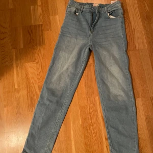 Blå jeansbyxor - Snygga blå jeansbyxor med en klassisk design. De är mid waist med raka ben, de passar dem som är 165 cm. Skulle säga att de är stora i storleken för de passar mig som har 34/S. Pris kan eventuellt diskuteras. 