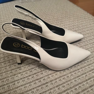 Vita klackskor från Boohoo - Snygga vita klackskor från Boohoo med spetsig tå och slingback-design. Perfekta för en elegant look.Bara testade! 