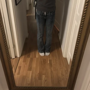 Blå bootcut jeans - Snygga blå bootcut jeans med låg midja och klassisk femficksdesign. Perfekta för en avslappnad stil. De har en dragkedja och knapp framtill. Midjemått 36/37 (stretchiga), skriv vid funderingar💕