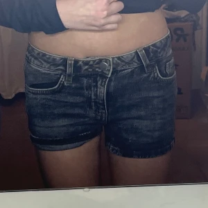 Mörkgråa jeansshorts - Snygga mörkgråa jeansshorts med låg midja och klassisk femficksdesign. Perfekta för en avslappnad stil. De har en dragkedja och knapp framtill. Man kan ha dom både uppvikta och nervikta längst ner. Dom kostade 250 kr i butik. Jag har använt dom runt 2 gånger så dom är som nytt skick. Så sköna och fina 😍😍