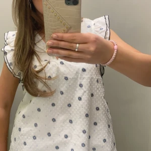 Vit blus med små blommor  - Jättesöt blus, knappt använd. Små mörkblå blommor på. Är i storleken 170 men skulle säga att de är som en xs-s💗