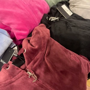 Vinröd set från Juicy Couture - Snygg och bekväm vinröd hoodie från Juicy Couture i mjukt material. Perfekt för en avslappnad stil med dragkedja och justerbar huva. Ett måste för garderoben! Byxan är s och kofta xxs(säljs pågrund av att jag fick flera i julklapp men jag gillar inte juicy 
