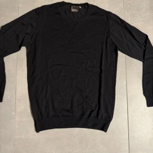 Svart tröja från Oscar Jacobson - Säljer en stilren svart tröja från Oscar Jacobson. Tröjan är långärmad och har en klassisk rund halsringning. Perfekt för en elegant och avslappnad look. Tröjan är i nyskick! Nypris 1600kr mitt pris 399kr! Hör av er vid fler frågor eller bilder!!