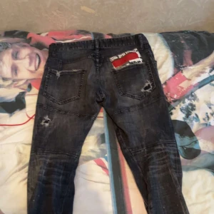 Svarta jeans med slitningar - Snygga svarta jeans med coola slitningar och detaljer. De har en klassisk femficksdesign och en modern look. Perfekta för en trendig stil. Dsq jeans 