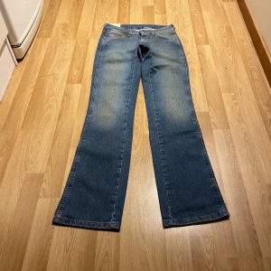 Lågmidjade bootcut jeans från Wrangler - (15) Så snygga Lågmidjade bootcut jeans från Wrangler, helt nya med lappar kvar! I en supersnygg tvätt. Midjemått rakt över: 34cm , innerbenslängd 86cm. Stretchiga!💓