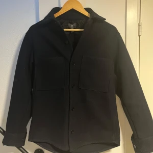 Mörkblå overshirt med knappar - Snygg mörkblå overshirt i tjockare material från HM. Bra skick!