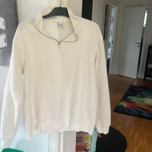 Vit tröja med dragkedja från Zara - Säljer en stilren vit tröja från Zara med dragkedja vid halsen. Tröjan har långa ärmar och en bekväm passform, perfekt för kyligare dagar. Passar bra till både jeans och mjukisbyxor. Hör av dig vid intresse!