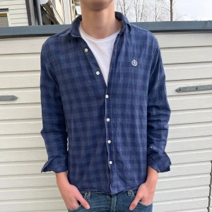 Flanellskjorta från Henry Lloyd - Snygg blå rutig skjorta från Henri Lloyd. Skick; 8.5/10 toppskick utan synliga defekter. Nypris ligger runt 1300kr men säljs nu flr endast 399kr. Hör gärna sv er vid minsta lilla fundering.