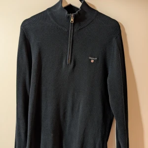 Mörkblå tröja med dragkedja från GANT - Snygg mörkblå tröja från GANT med halv dragkedja och ribbad krage. Varsamt använd fåtal gånger, säljes pga att jag har gått upp i vikt (pga gym). Det är medium i storlek och är true to size. 