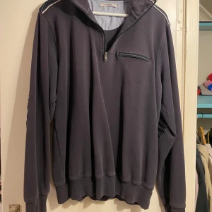 Mörkgrå tröja från Dressmann - Säljer en mörkgrå tröja från Dressmann med dragkedja vid halsen och en bröstficka med dragkedja. Tröjan har långa ärmar och ribbade muddar vid ärmslut och nederkant. Perfekt för en avslappnad stil. Ganska mycket använd men inga synliga defekter, fler bilder kan får i dm:) pris kan diskuteras!💕