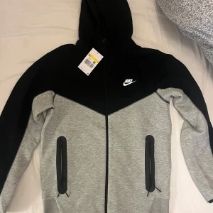 Nike tech tracksuit - Hej alla! Jag säljer en otroligt snygg Nike Tech tracksuit (ej använd alls då jag köpte i fel storlek och retur tiden hade löpt ut)till ett fantastiskt pris! Jag har prislapparna kvar och kvittot från beställningen för att garantera äktheten. Kontakta mig snabbt för att göra detta fynd! 