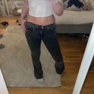 Svarta jeans från Perfect Jeans - Snygga mörk gråa jeans i storlek 34. De har en klassisk design med en rak passform och är perfekta för en stilren look. Jeansen har en knapp och dragkedja framtill. Lite slitna längst ner. 