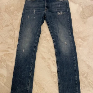 Blå jeans från Replay strl 12A - Blå jeans från Replay, modell Mini Waitom. De har en klassisk femficksdesign och slitna detaljer för en trendig look. Köparen står för frakt.