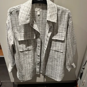Vit och svart rutig overshirt från H&M - Nästan aldrig använd jättefin vit och svart rutig overshirt från H&M med långa ärmar och knappar framtill. 