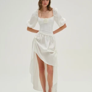 Vit For Love & Lemons klänning, XXS-XS. NY!  - Årets finaste maxiklänning från for Love & Lemons! Söt, romantisk stil och är perfekt för speciella tillfällen eller som en statement-piece i garderoben.   Med puffiga ärmar, asymmetrisk kjol med rosor, en figursydd överdel och ett vackert byst-parti är det en riktig sommardröm.  Storlek XXS, men jag skulle helt klart säga att den är mer en XS. Är 154 cm och har små bröst, både för lång och för stor för mig i bysten tyvärr.  Den är sprillans ny, har endast provat den lappar finns kvar!