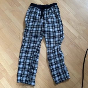 Rutig byxa från Kappahl - Säljer ett par bekväma rutiga byxor från Kappahl i storlek 146/152. Byxorna har ett elastiskt midjeband och snörning för justerbar passform. Perfekta för en avslappnad stil.