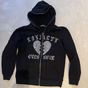 Svart hoodie BVALDI - Snygg svart hoodie med dragkedja och huva. Väldigt bra skick, det är inga fläckar eller hål och alla diamanter sitter kvar.                                                Orginalpris: 1099kr.                                                         Jag säljer den för endast 699 men priset går att förhandla 