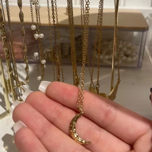 Guldigt halsband med månhänge - Elegant guldigt halsband med ett vackert månhänge. Kedjan är tunn och smidig. aldrig använd