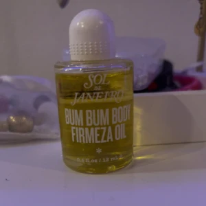 Bum Bum Body Firmeza Oil från Sol de Janeiro - Säljer en flaska Bum Bum Body Firmeza Oil från Sol de Janeiro. Denna kroppsolja kommer i en liten, genomskinlig flaska med vit kork och innehåller 12 ml. Perfekt för att ge huden en mjuk och återfuktad känsla. 