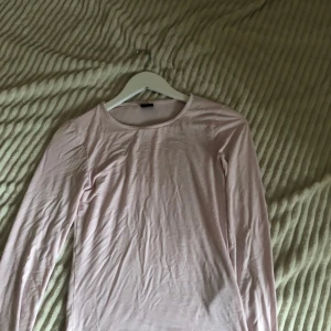 Ljusrosa långärmad topp från Gina Tricot - Säljer en ljusrosa långärmad topp från Gina Tricot. Perfekt för en stilren och enkel look. Toppen är i en mjuk och bekväm bomullsmix. Passar Xs - m ! 