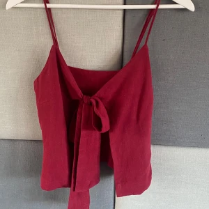 Röd linnetopp med knytband - Snygg röd linnetopp med smala axelband och knytband framtill. Skräddarsydd i Vietnamn❤️ storlek är xs/s skulle jag säga 