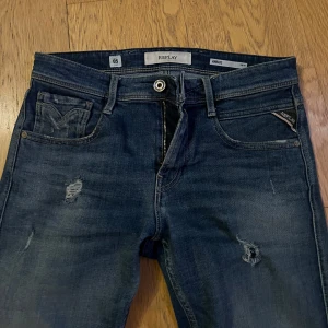 Blå jeans från Replay - Snygga jeans från Replay med slitna detaljer. Vintage jeans demin! Finns inte att köpa längre. Blåa jeans med snygg tvättning! Storlek W30. Mycket bra skick och knappt använda.