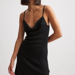 Glittrig stickad mini klänning - Glittrig svart klänning perfekt till både jul och nyår, den är i ett tunt stickat material i mycket väl skick då den aldrig kommit till användning och prislapp finns kvar.