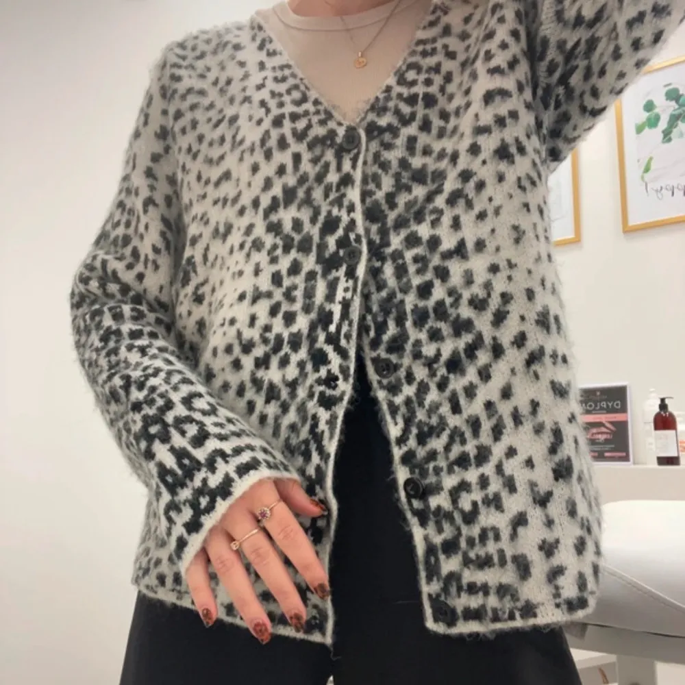 Säljer en mysig kofta från Jaded London i svart och vit med leopardmönster. Koftan har en v-ringad design och knappar framtill. Perfekt för att hålla sig varm och stilren.. Neuletakit & Villapaidat.