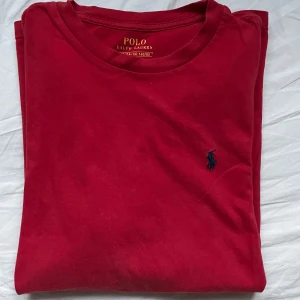 Ralph Lauren t-shirt - Snygg röd t-shirt från Ralph Lauren med klassisk passform. Den har en liten broderad logga på bröstet i blått. Storlek L/G (14-16) men sitter bra på dig som bär S