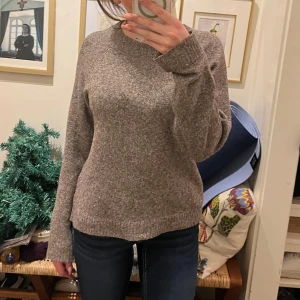 Brun stickad tröja - Mysig brun stickad tröja med långa ärmar. Perfekt för kyligare dagar och ger en avslappnad look. Passar bra till jeans eller kjol.