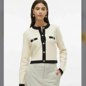 Vit och svart kofta med guldknappar - Elegant vit kofta med svarta detaljer och guldknappar. Den är i storlek M men jag tycker att den är väldigt liten för att vara M, så jag skulle säga att den är i storleken S. Den är helt ny, har aldrig använt den 