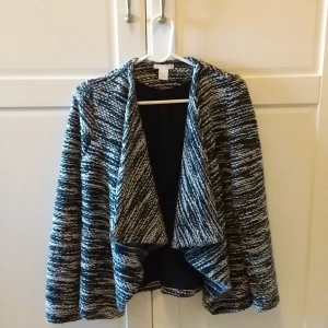 Svartvit mönstrad jacka - Snygg svartvit mönstrad jacka med öppen front och långärmad design. Perfekt för lager-på-lager och ger en stilren look. Passar bra till både vardag och mer uppklädda tillfällen.