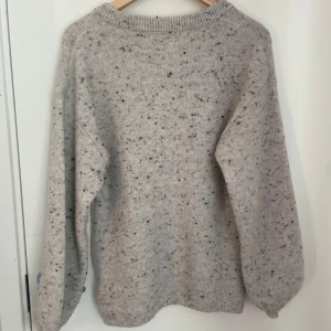 Grå stickad tröja från BikBok - Mysig grå stickad tröja från BikBok med ett diskret melerat mönster. Perfekt för kyliga dagar med sin bekväma passform och långa ärmar. En stilren och enkel design som passar till det mesta och är väldigt höstig❤️